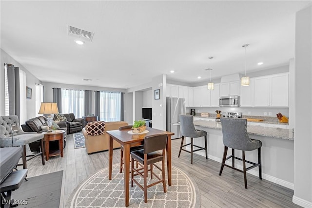 dining room with light wood-style floors, visible vents, and recessed lighting