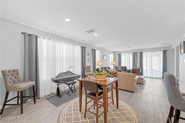 dining room with light wood-type flooring, visible vents, and recessed lighting