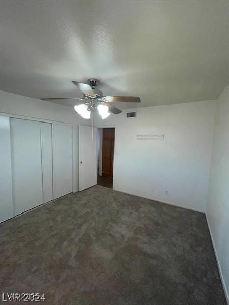 unfurnished bedroom featuring a closet, carpet, visible vents, and a ceiling fan