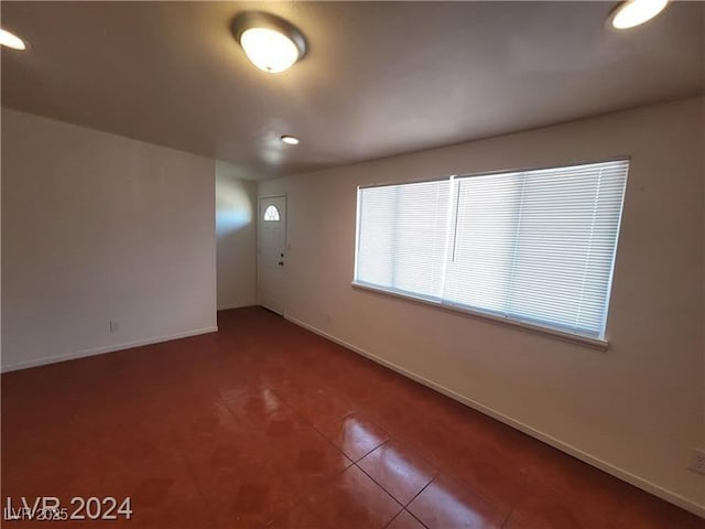 unfurnished room with tile patterned flooring and baseboards