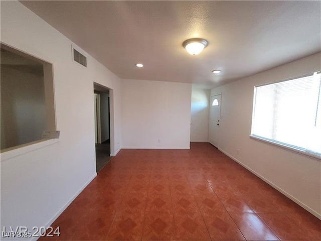 empty room featuring recessed lighting, visible vents, and baseboards