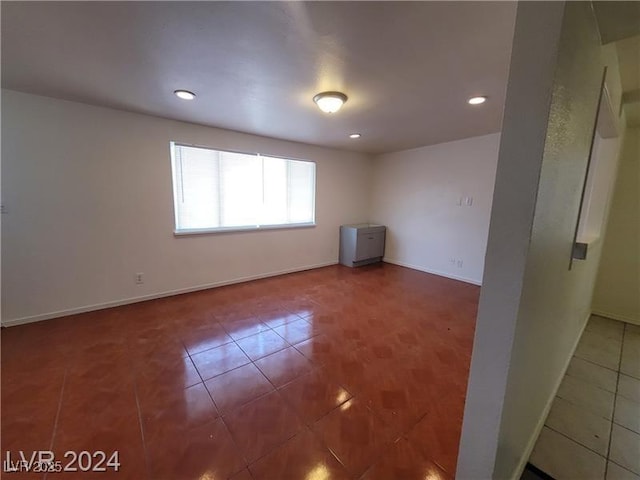 tiled spare room featuring baseboards and recessed lighting