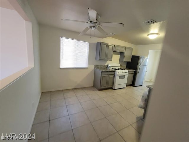 kitchen with ceiling fan, gray cabinetry, white range with gas stovetop, visible vents, and freestanding refrigerator