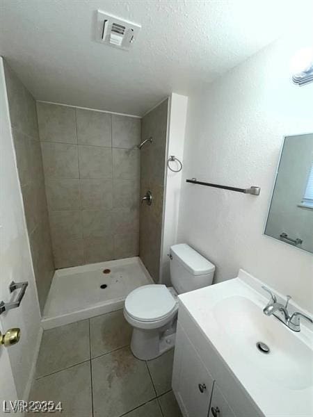 full bathroom with visible vents, tiled shower, toilet, tile patterned floors, and a textured ceiling