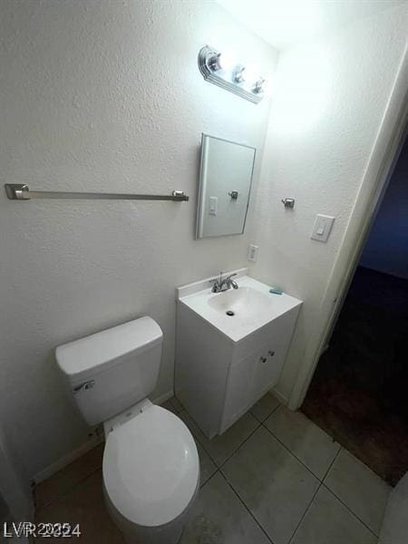 bathroom featuring tile patterned flooring, vanity, and toilet