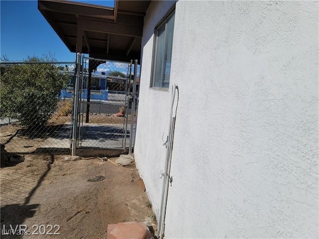 exterior space featuring a gate and stucco siding