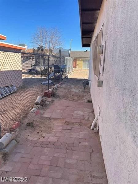 view of side of home with fence and stucco siding