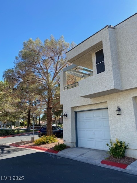 view of side of home featuring a garage and stucco siding