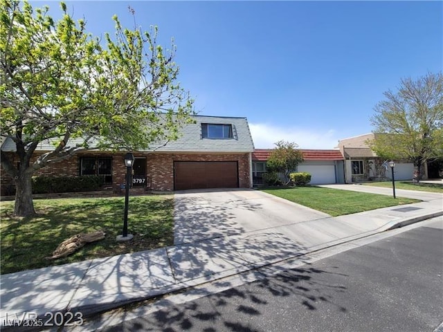 view of front of home with a garage, concrete driveway, a front lawn, and brick siding