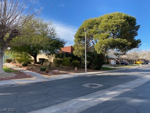 view of street featuring traffic signs, curbs, and sidewalks