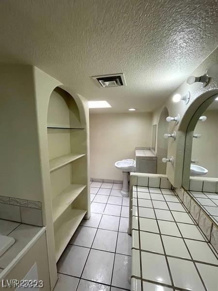 full bathroom featuring visible vents, a textured ceiling, toilet, and tile patterned floors