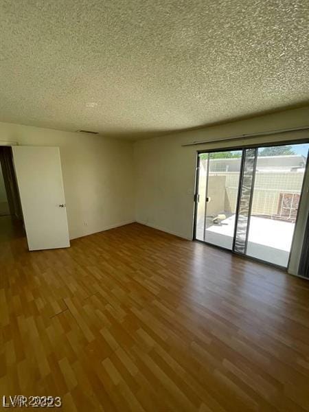 spare room featuring a textured ceiling and wood finished floors