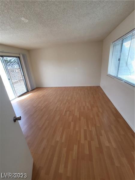 empty room with light wood-style flooring and a textured ceiling