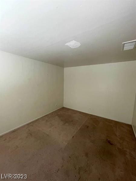 carpeted empty room featuring visible vents