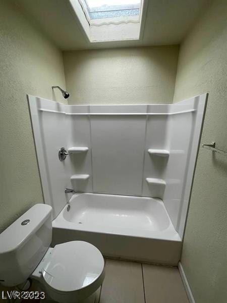 bathroom featuring toilet, tile patterned flooring,  shower combination, and a textured wall