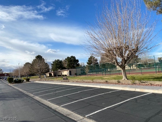 uncovered parking lot featuring fence