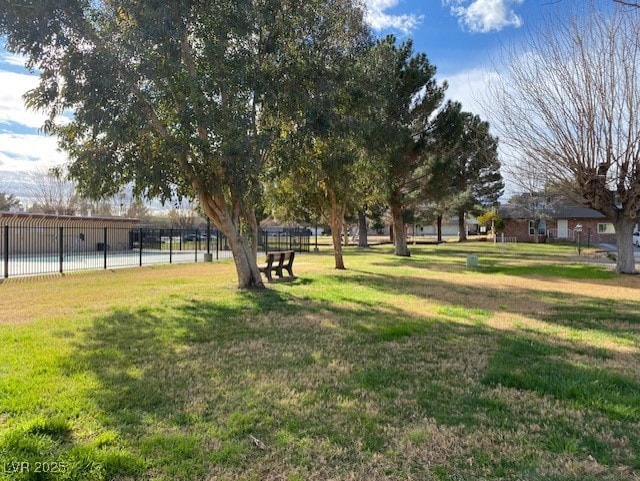 view of home's community featuring fence and a lawn