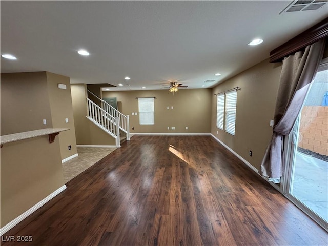 interior space with visible vents, stairway, baseboards, and wood finished floors