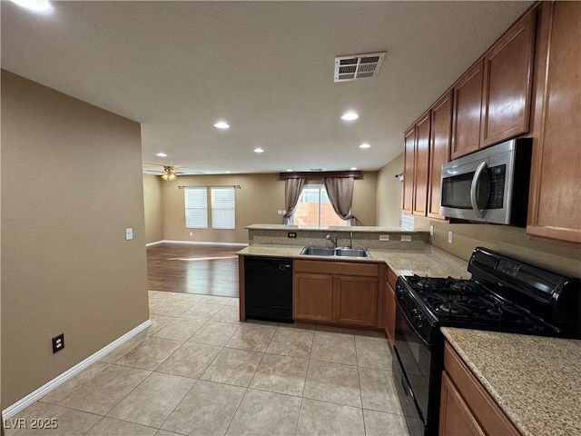 kitchen featuring visible vents, open floor plan, a peninsula, black appliances, and a sink