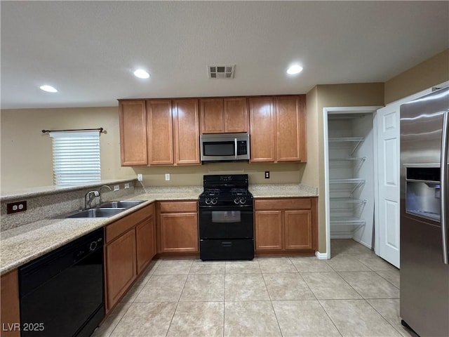 kitchen featuring recessed lighting, a sink, visible vents, brown cabinets, and black appliances