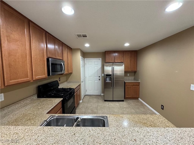 kitchen with brown cabinets, recessed lighting, light countertops, visible vents, and appliances with stainless steel finishes