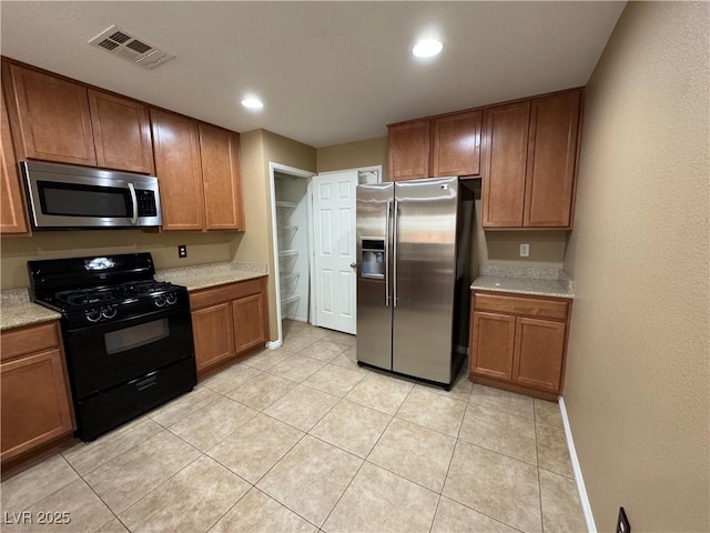 kitchen with light tile patterned floors, visible vents, brown cabinetry, stainless steel appliances, and recessed lighting