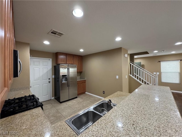 kitchen featuring stainless steel appliances, recessed lighting, visible vents, brown cabinetry, and a sink