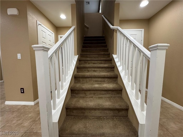 stairway featuring tile patterned flooring, baseboards, and recessed lighting