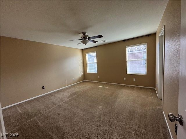 empty room featuring baseboards, visible vents, ceiling fan, a textured ceiling, and carpet floors