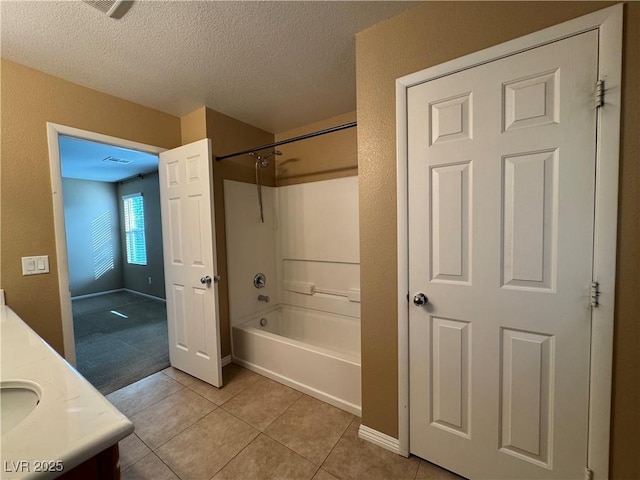 full bathroom with vanity, a textured ceiling, shower / tub combination, baseboards, and tile patterned floors