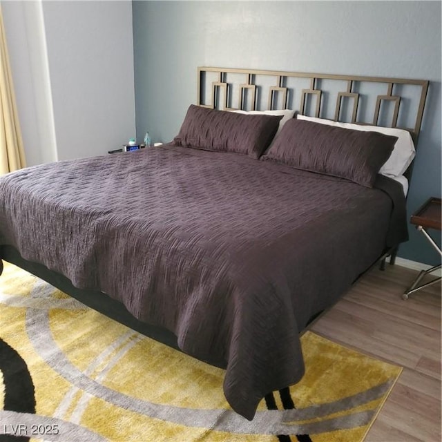 bedroom with baseboards and wood finished floors