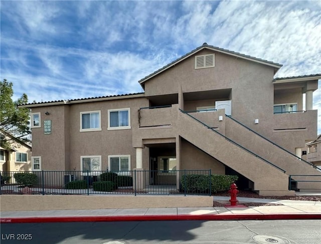 view of property with stairs and fence