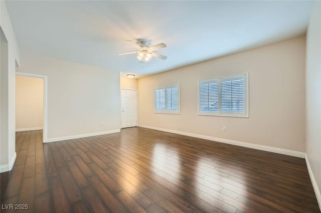 unfurnished room with dark wood-style floors, baseboards, and ceiling fan