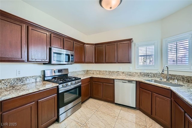 kitchen featuring a sink, light stone counters, marble finish floor, and stainless steel appliances