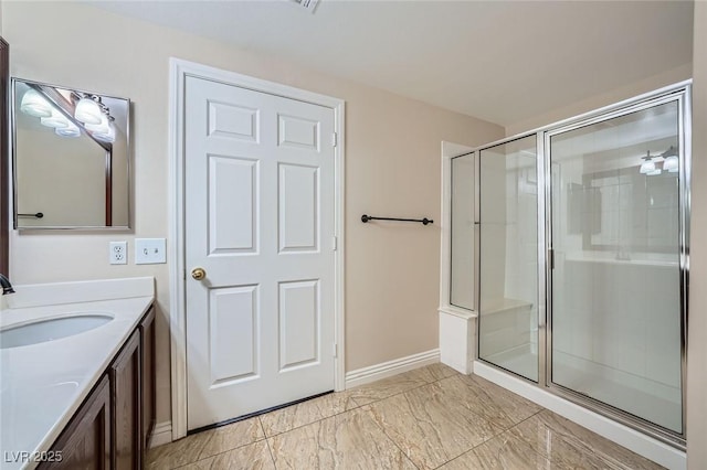 bathroom featuring baseboards, marble finish floor, a stall shower, and vanity