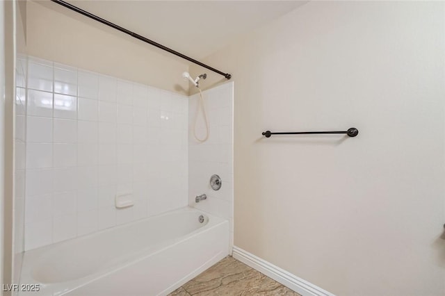 bathroom featuring bathtub / shower combination and baseboards