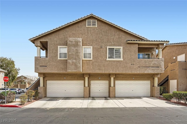 townhome / multi-family property with an attached garage, driveway, and stucco siding