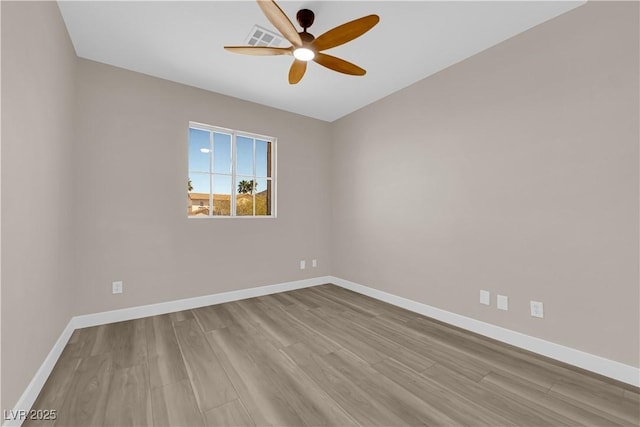 empty room with baseboards, visible vents, and wood finished floors