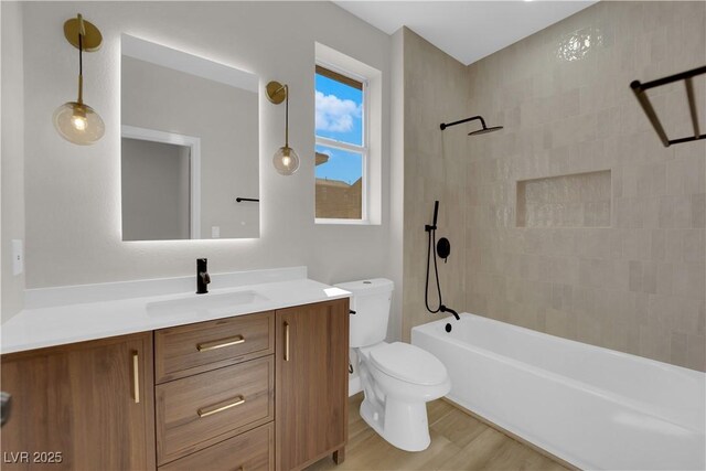 full bathroom featuring toilet, tub / shower combination, wood finished floors, and vanity