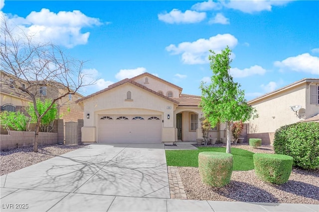 mediterranean / spanish home featuring concrete driveway, a tiled roof, an attached garage, fence, and stucco siding