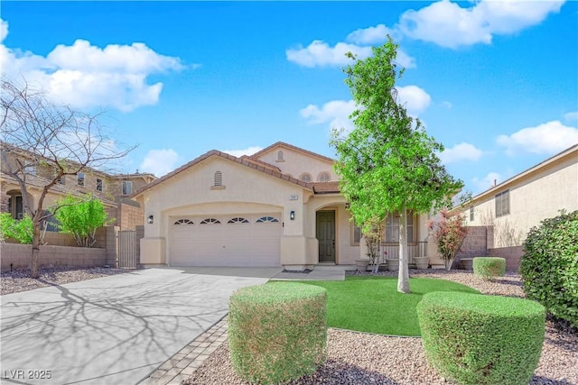 mediterranean / spanish-style home with a tile roof, stucco siding, concrete driveway, fence, and a garage