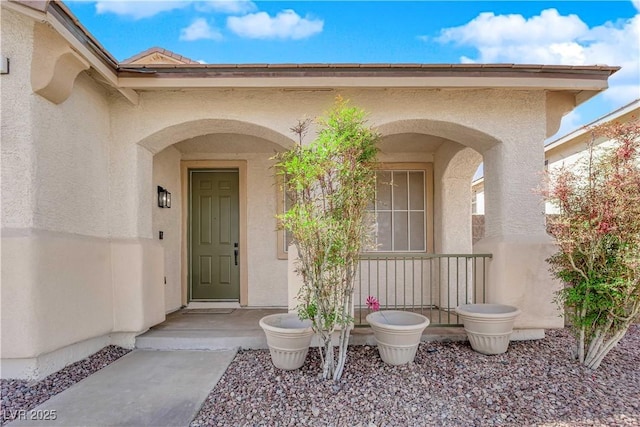 doorway to property featuring stucco siding