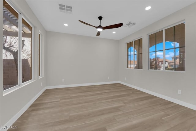 empty room featuring light wood-type flooring, visible vents, and recessed lighting