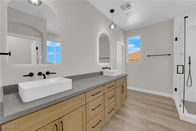 full bathroom featuring double vanity, a sink, visible vents, and a shower stall