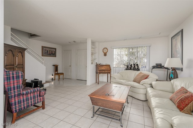 living room featuring light tile patterned floors and stairway