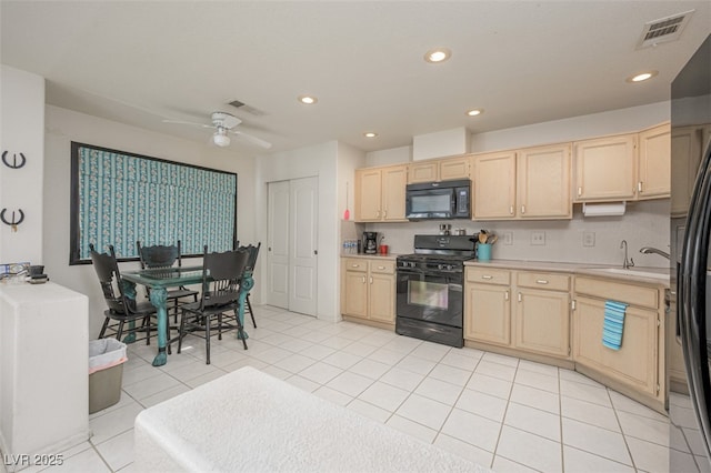 kitchen featuring light brown cabinets, a sink, visible vents, and black appliances