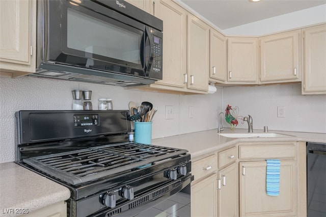 kitchen with light countertops, a sink, black appliances, and light brown cabinetry