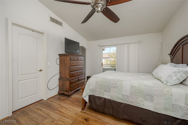 bedroom with lofted ceiling, wood finished floors, visible vents, and a ceiling fan