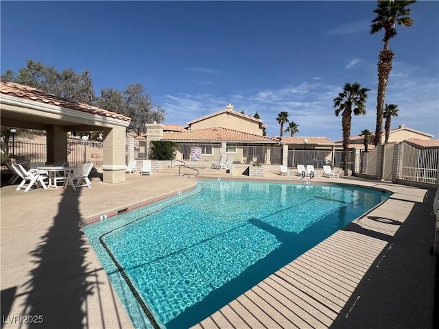 pool with fence and a patio