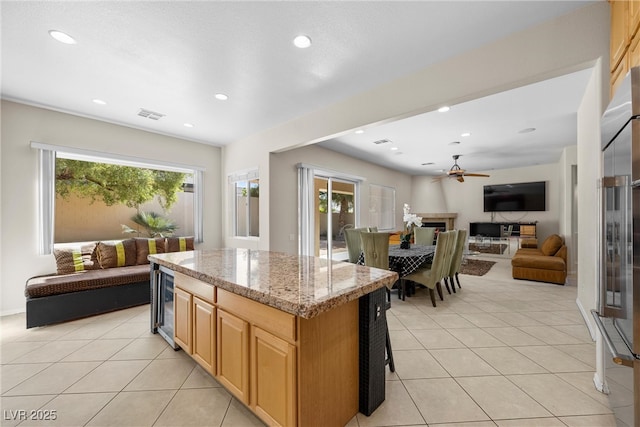 kitchen featuring a center island, open floor plan, light tile patterned flooring, and stainless steel built in refrigerator